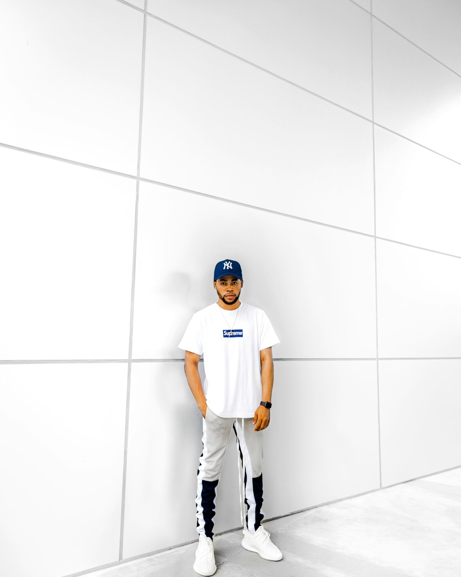 man wearing white crew-neck t-shirt and grey pants and fitted cap